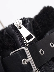 Détail de la fermeture éclair argentée et lanière cuir sur veste polaire noire