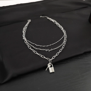 Detail view of silver triple-layered necklace with Angel charm and heart lock pendant