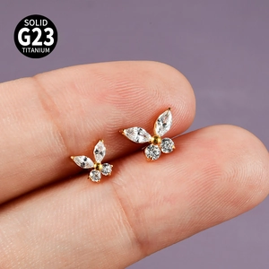 Detailed close-up of golden G23 titanium butterfly stud earring with clear zircon
