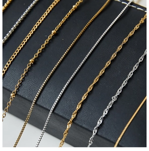 Detailed view of assorted gold and silver stainless steel necklace chains on black box