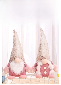 Close-up of pink sequined Christmas gnomes with white beard and braided pigtails
