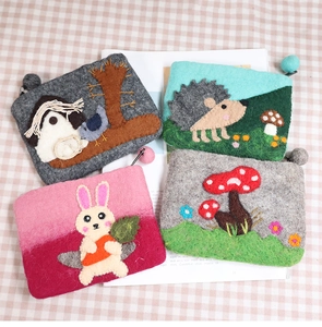 Detailed view of handmade wool felt coin purses with cute animal embroidery and zippers