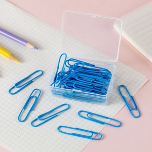 Close-up of blue metal paper clips with transparent storage box on pink desktop background