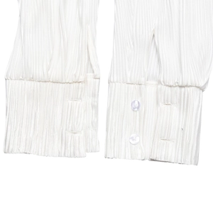 Detail shot of white pleated shirt cuffs with button tabs and small round buttons