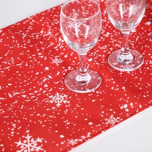 Red Christmas table runner with white snowflake pattern and festive fabric texture