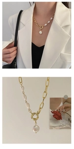 Detail of vintage Baroque pearl necklace with gold chain and ring clasp on white blazer
