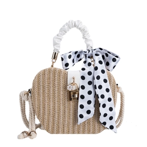 Fashionable straw shoulder bag with white faux leather handle and polka dot silk scarf detail