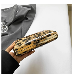 Macro view of leopard print clutch with golden metal frame and luxury texture
