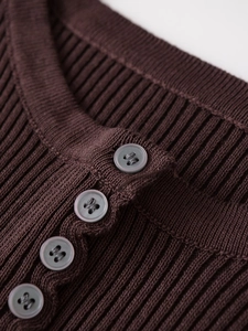 Close-up of dark brown ribbed knit sweater featuring a four-button placket detail