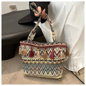 Detail of bohemian woven tote bag showing colorful ethnic patterns and vibrant tassels