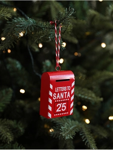Close-up of red metal 'Letters to Santa' mailbox ornament hanging on a Christmas tree