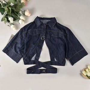 Detail of cropped blue denim jacket with unique buckle rings and cross-strap waist design
