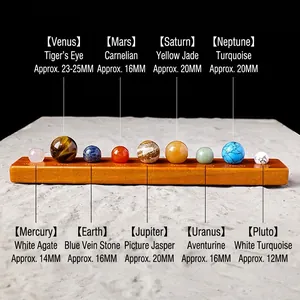 Solar system crystal ball set with nine natural gemstones on an orange wood base