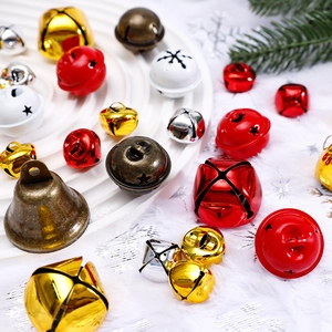 Assorted Christmas metal bells in red, gold and silver on a festive white textured tray