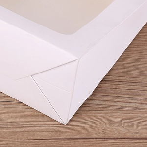 Macro detail of white gift box with transparent window and sturdy folded corner structure
