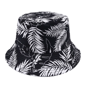 Detailed view of bucket hat featuring black and white tropical leaf patterns and cotton fabric