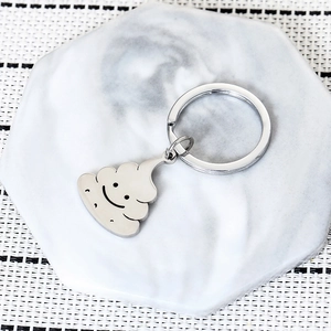 Close-up of funny silver stainless steel keychain with a cute 3D poop emoji charm