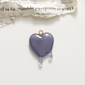 Close-up of a blue resin melting heart pendant with gold ring for DIY jewelry making