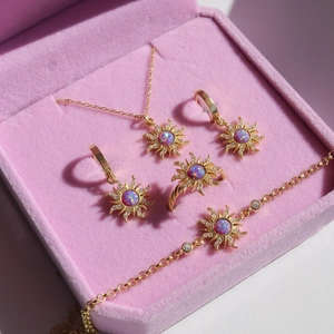Detail of opal sunburst jewelry set including necklace and earrings in pink velvet box