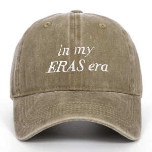 Detail of vintage washed cotton fabric and embroidered 'in my ERAS era' text on baseball cap