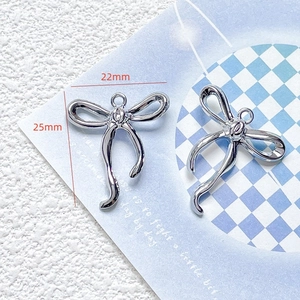 Macro shot of silver bow pendant with 22mm x 25mm dimensions for DIY jewelry making