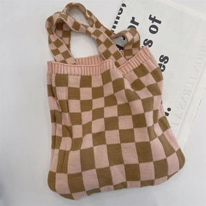 Detail of pink and khaki checkered knit tote bag with visible woven texture and ribbed edge