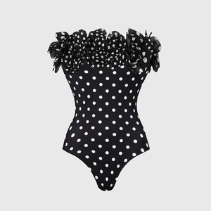 Detailed view of polka dot swimsuit with decorative ruffled mesh floral neckline trim