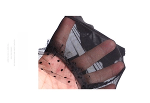 Detailed macro view of black polka dot mesh fabric with delicate lace texture