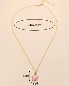 Detail view of a gold turtle pendant necklace with pink flower shell and size dimensions
