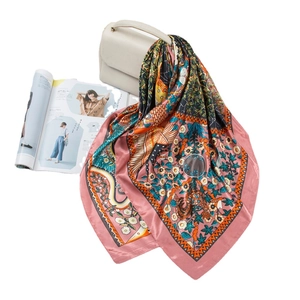 Pink border satin square scarf with floral and bird print draped over a white handbag