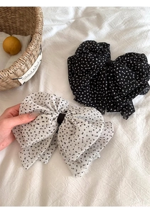 Detailed view of the large French-style polka dot chiffon bow hair clips in black and white