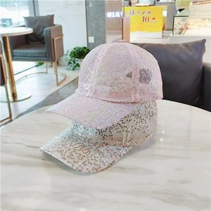 Detail view of sparkly sequins on pink and champagne gold baseball caps for women