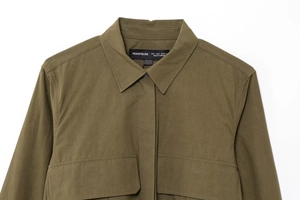 Detail of army green utility shirt collar and symmetrical chest pockets with buttons
