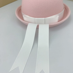 Details des rosa JK-Uniform-Filzhutes mit weißer Schleife und Zierbändern