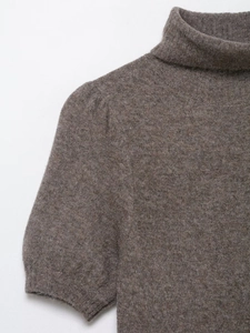Close-up of brown knit turtleneck dress showing soft wool texture and puff sleeves