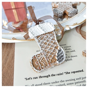 Detailed view of gingerbread style Christmas stocking ornament with brown ribbon
