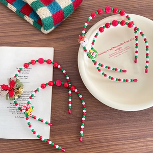 Handmade Christmas beaded headbands with Santa Claus and reindeer on a festive table