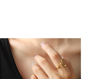 Primer plano detallado de un anillo abierto dorado con cuentas esféricas en la mano