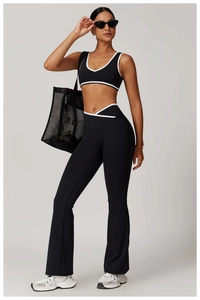 Détail d'un ensemble de sport noir avec bordure blanche et pantalon de yoga évasé chic