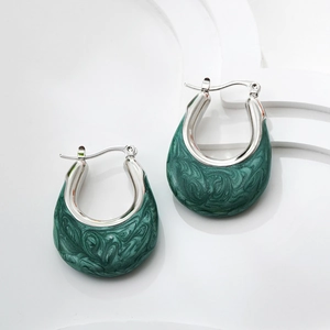 Macro detail of U-shaped silver hoop earrings with dark green marble enamel inlay