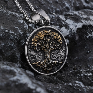 Macro view of vintage silver and gold Tree of Life pendant on textured rock background