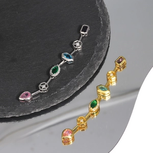 Detailed close-up of multi-color zircon pendant on black stone with clear mirror reflection