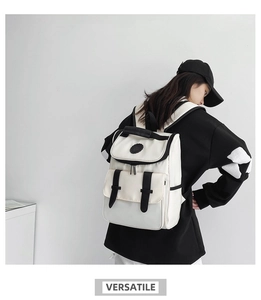 Rear view of a minimalist black and white canvas backpack on a model showing side pockets