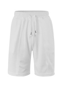 Detail shot of white waffle knit fabric texture and elastic drawstring waistband on shorts