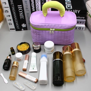 Purple quilted makeup bag with green handle showing large capacity storage for cosmetics