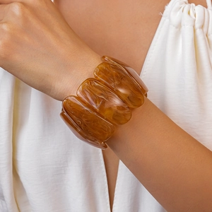 Macro detail of amber resin chunky elastic bracelet with tortoiseshell pattern texture