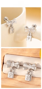 Detail of silver bow earrings with lock pendants and sparkling star-shaped stones