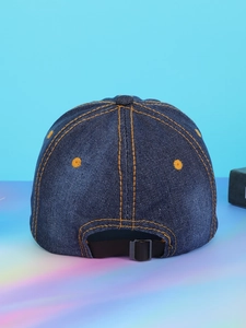 Detail of adjustable metal buckle and stitching on blue denim baseball cap