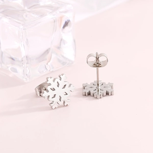 Detailed view of silver snowflake earrings with back studs on pink background