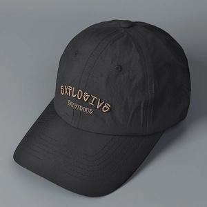 Detail of embroidered EXPLOSIVE text on a black retro quick-dry baseball cap